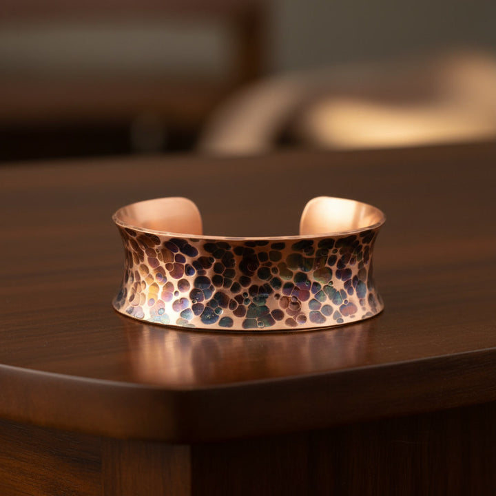 Copper candle holder with mosaic design on a wooden surface