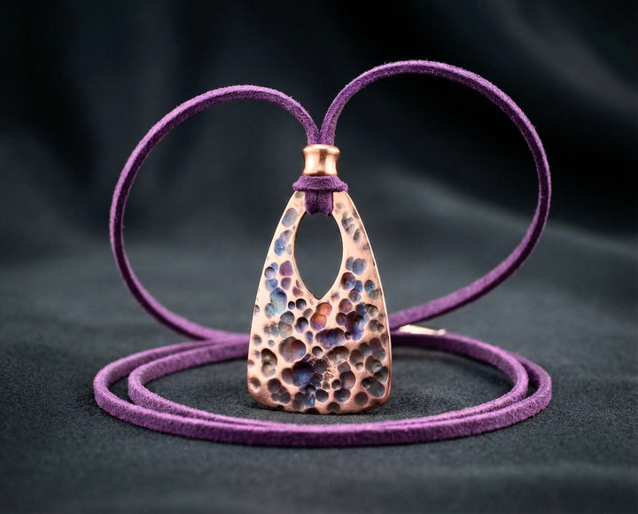 Purple leather necklace with a textured pendant on a dark background