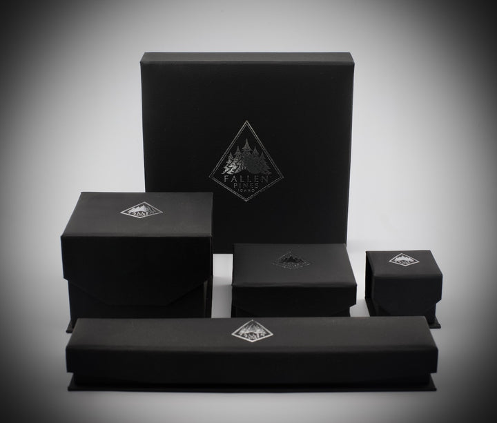Set of black boxes with a Fallen Pines logo on a gray background