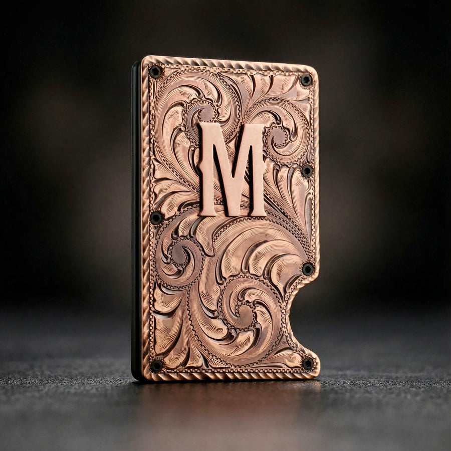 Decorative metal wallet with intricate patterns and a letter 'M' on a dark background