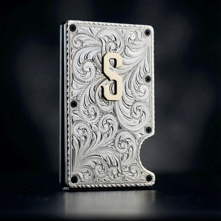 Decorative metallic wallet with intricate patterns and a brass symbol on a dark background