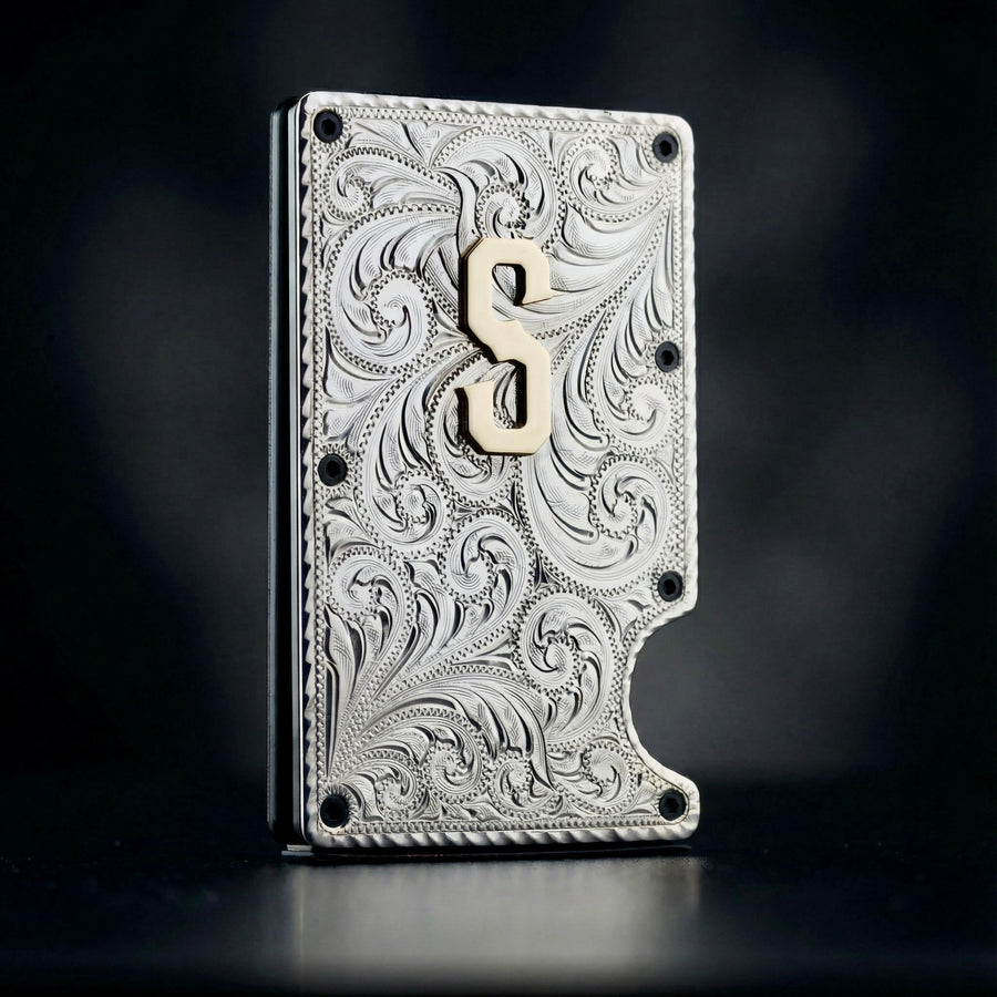 Decorative metallic wallet with intricate patterns and a brass symbol on a dark background