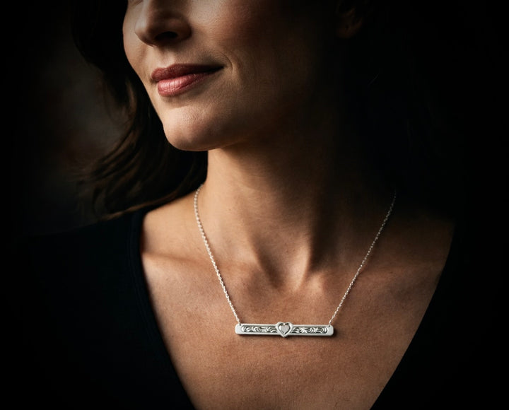 Woman wearing a silver necklace with a dark background