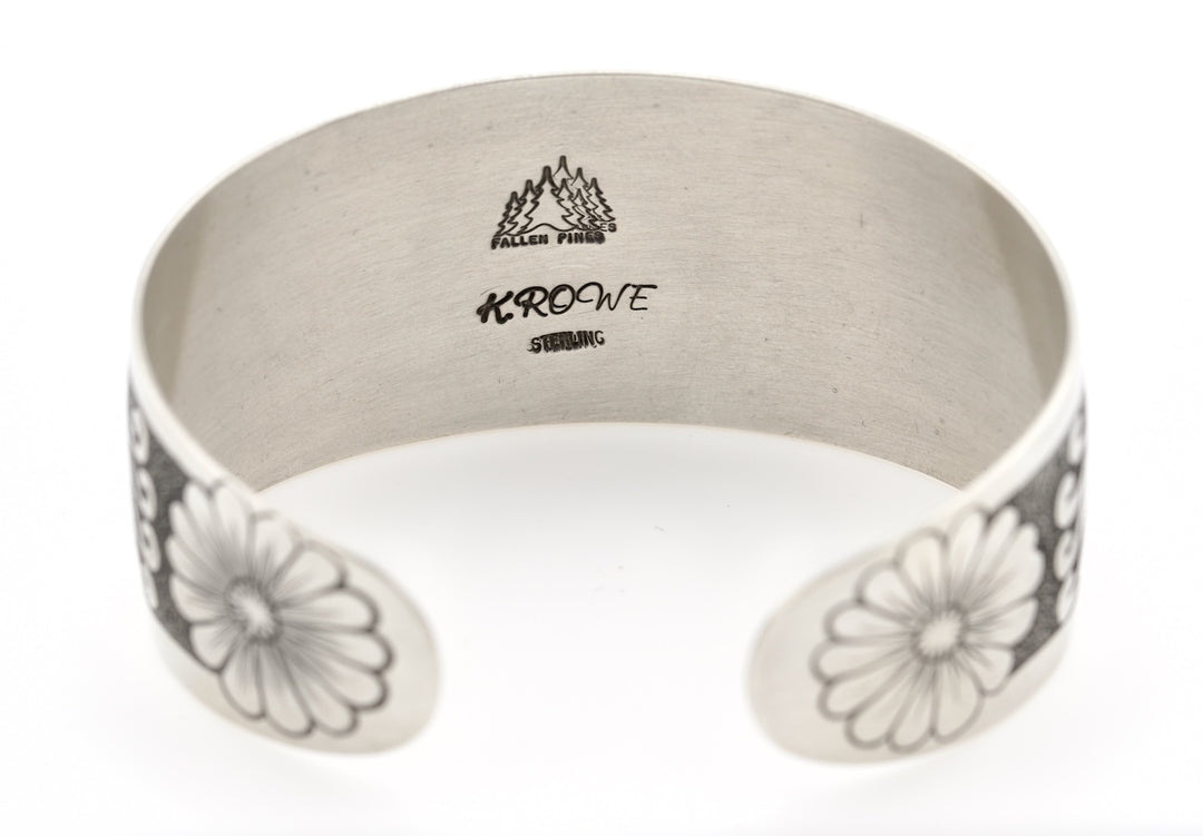 Silver bracelet with floral patterns and 'Fallen Pines' branding on a white background
