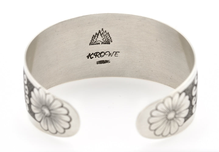 Silver bracelet with floral patterns and 'Fallen Pines' branding on a white background
