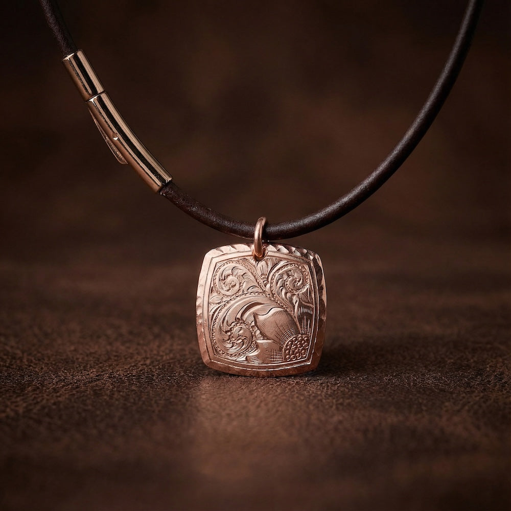 Decorative pendant on a leather cord against a brown background