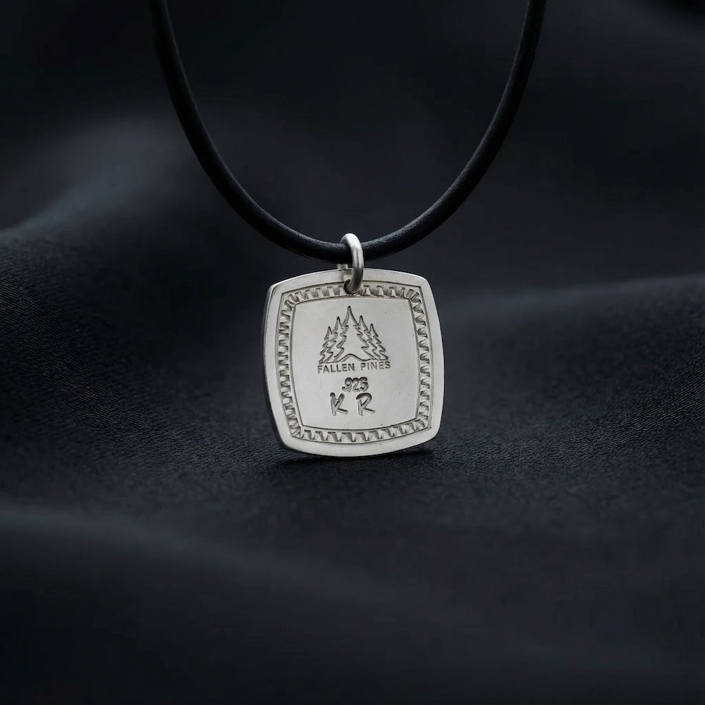 Silver pendant necklace on a dark background