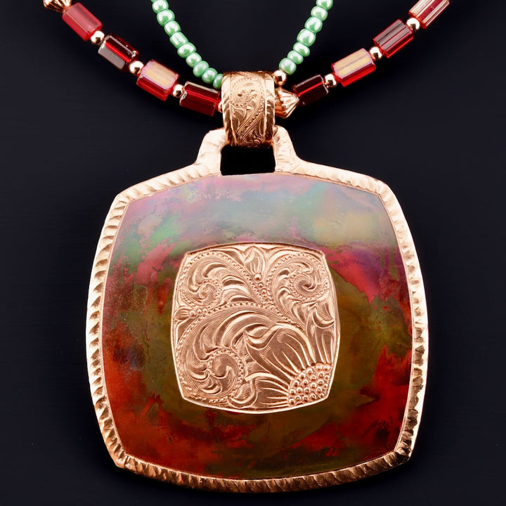 Copper pendant with intricate design on a dark background