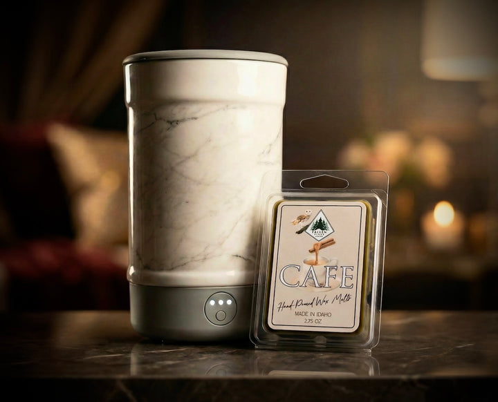 Marble-patterned wax warmer with a 'Cafe' wax melt package on a blurred background