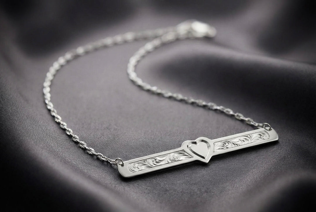 Silver bracelet with heart design on a dark fabric background